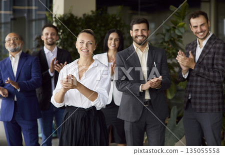 Happy applause of female business leader and office team standing together Happy applause of female business leader and office team standing together 135055558