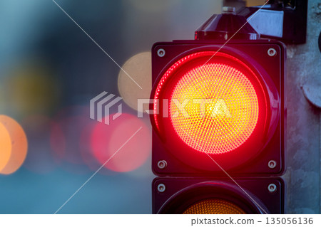Traffic light shows red signal for cars at intersection during evening rush hour 135056136