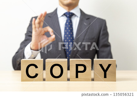 A businessman making an OK pose with a block that says "COPY" A businessman making an OK pose with a block that says "COPY" 135056321