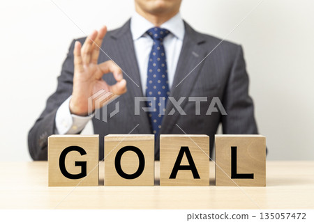 A businessman making an OK pose with a block that says "GOAL" A businessman making an OK pose with a block that says "GOAL" 135057472