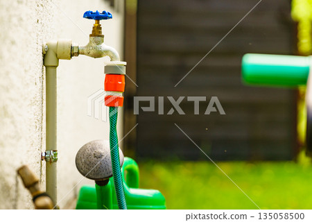 Garden tap with hosepipe attached. Garden tap with hosepipe attached. 135058500