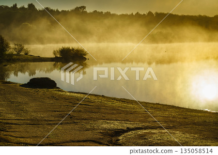Morning fog over autumn lake water Morning fog over autumn lake water 135058514