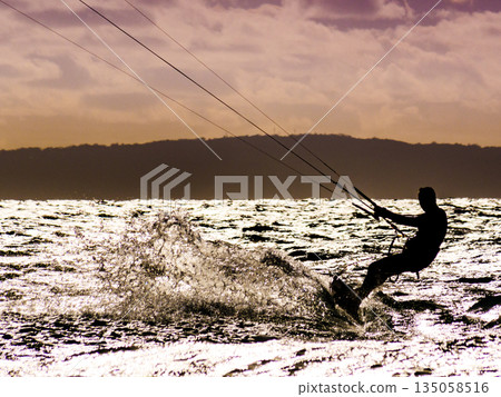 Kite surfer riding waves. Kiteboarding sport. 135058516