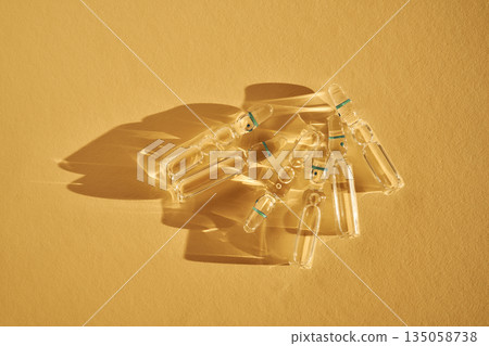 Glass ampoules with clear liquid producing light reflections Glass ampoules with clear liquid producing light reflections 135058738