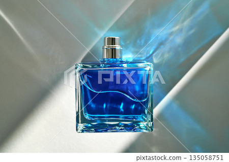 Blue perfume bottle reflecting abstract light and shadows Blue perfume bottle reflecting abstract light and shadows 135058751