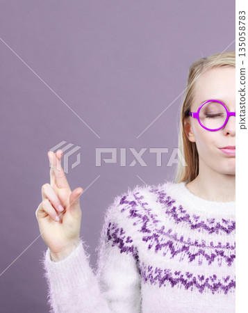 Teenage blonde woman making promise gesture 135058783