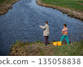 Boys children catch fish near the river. View from behind. 135058838