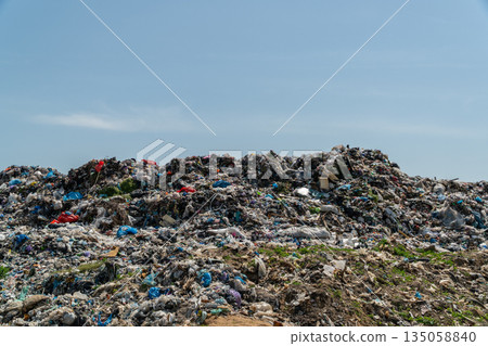 A vast landscape filled with heaps of garbage, reflecting the ongoing crisis of waste management and its threat to ecological balance A vast landscape filled with heaps of garbage, reflecting the ongoing crisis of waste management and its threat to ecological balance 135058840