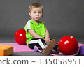 Two year old girl doing sports posing with skipping rope and ball on grey background.Sports activities with little kids. 135058951