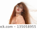 Beautiful girl with developing red hair on a white background. 135058955