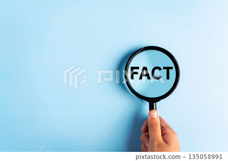 Fact - Word through magnifying glass on blue background. 135058991