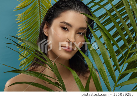 Asian beautiful girl standing among tropical plants leaves. 135059293