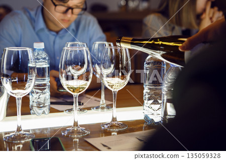 Man Pouring Wine Into Wine Glasses in Sommelier Courses, Close up 135059328