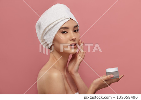 Female model demonstrates container for moisturizer. Female model demonstrates container for moisturizer. 135059490