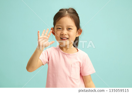Delighted Lovely five year old kid Girl joyful waves her hand to you stands over blue isolated. Cheerful little child portrait on turquoise background. Delighted Lovely five year old kid Girl joyful waves her hand to you stands over blue isolated. Cheerful little child portrait on turquoise background. 135059515
