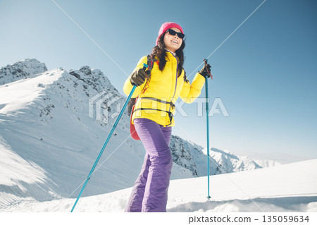 Smiling Woman Hiking in Snowy Mountains With Trekking Poles During Winter Smiling Woman Hiking in Snowy Mountains With Trekking Poles During Winter 135059634