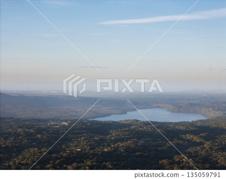 View of a lake from a high point near the forest on a clear day View of a lake from a high point near the forest on a clear day 135059791