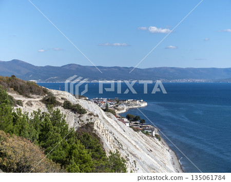 Panoramic view of the sea from a rocky hillside with pine trees under a clear blue summer sky Panoramic view of the sea from a rocky hillside with pine trees under a clear blue summer sky 135061784