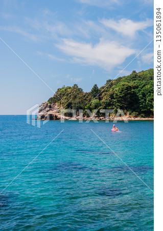 Coastline meets vibrant turquoise sea. Coastal scenery, summer nature, and serene outdoor exploration. Coastline meets vibrant turquoise sea. Coastal scenery, summer nature, and serene outdoor exploration. 135061894
