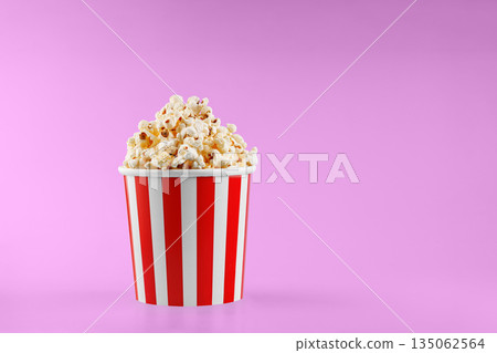 Classic red striped popcorn cardboard cup on Pink background 135062564