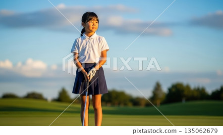 一位青少年高爾夫球手手持推桿，眺望著遠方的球場。 135062679