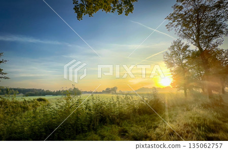 A Beautiful Sunrise Over a Vast and Serene Landscape Awaits You and Inspires Tranquility A Beautiful Sunrise Over a Vast and Serene Landscape Awaits You and Inspires Tranquility 135062757