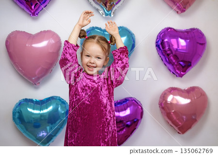 A laughing little girl waves her hands greeting and congratulating on Valentine's Day A laughing little girl waves her hands greeting and congratulating on Valentine's Day 135062769