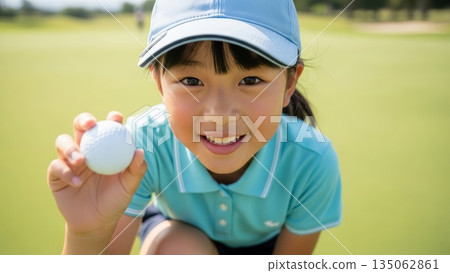 可愛的青少年高爾夫球手手持高爾夫球，微笑著看著鏡頭。 135062861