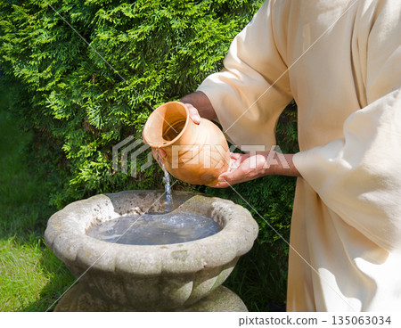Hands pour water into the pot 135063034