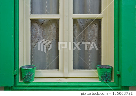 Colorful window with flower pots in the town of Vourliotes Colorful window with flower pots in the town of Vourliotes 135063781