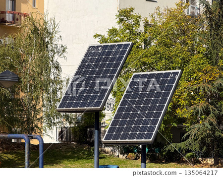 Solar panels installed in urban park. Renewable energy, sustainable technology and eco-friendly infrastructure in public space. Solar panels installed in urban park. Renewable energy, sustainable technology and eco-friendly infrastructure in public space. 135064217