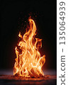 Bright flames dance in a black background, creating warmth and energy during a cozy evening 135064939