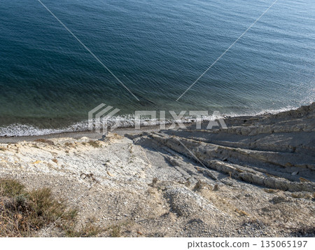 Top view of sea, rocky shoreline and coastal cliffs. Natural seascape with rocks and water, no people Top view of sea, rocky shoreline and coastal cliffs. Natural seascape with rocks and water, no people 135065197