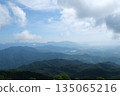 A breathtaking view of a majestic mountain range, with a few scattered clouds in the sky 135065216