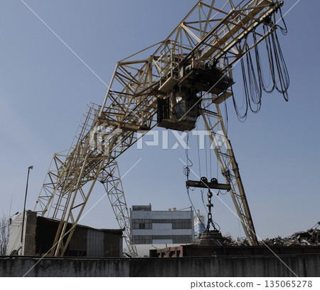 Magnetic Gripper Of Gantry Crane At Works On A Scrap Yard 135065278