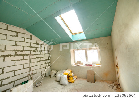 Interior of an apartment room with bare walls and ceiling under construction. 135065604
