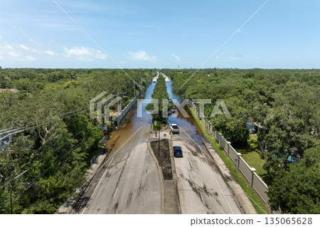 Hurricane flooded car on city street in surrounded with water Florida residential area. Consequences of hurricane Debby natural disaster 135065628