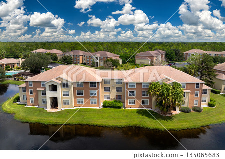 Florida suburban condos with car parking, highlighting residential architecture and real estate expansion in American communities Florida suburban condos with car parking, highlighting residential architecture and real estate expansion in American communities 135065683