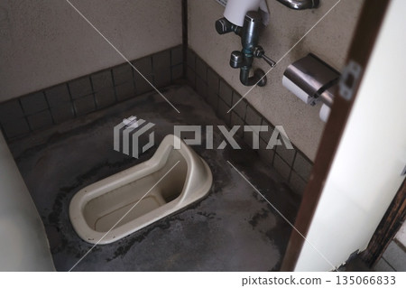 Dirty old Japanese style toilet and trash on the floor. Dirty old Japanese style toilet and trash on the floor. 135066833