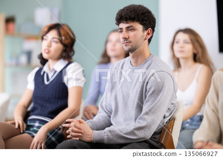 Young guy listening during seminar in a modern classroom 135066927