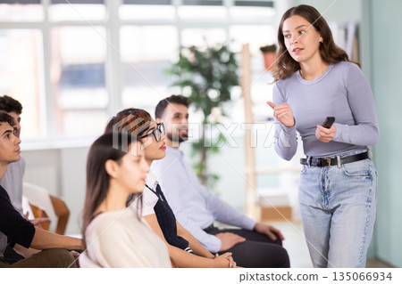 Female teacher explaining topic to students using digital board Female teacher explaining topic to students using digital board 135066934