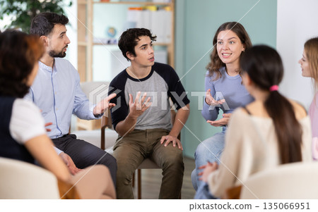 Group of students sitting in a circle and chatting 135066951