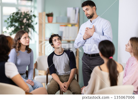 Male teacher talking to interested students sitting in a circle 135067006