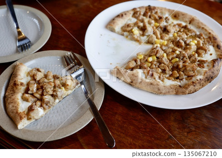 Japanese-style pizza topped with teriyaki chicken and corn. 135067210