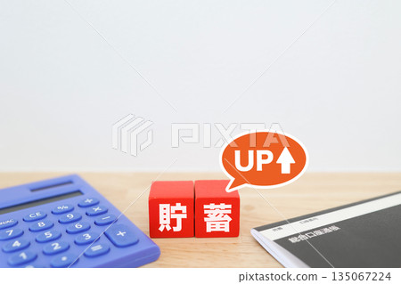 A household finances image showing increased savings. A calculator and a bankbook. A household finances image showing increased savings. A calculator and a bankbook. 135067224