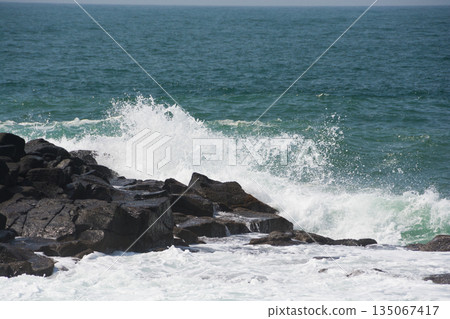 A wave that hits a rock and breaks A wave that hits a rock and breaks 135067417