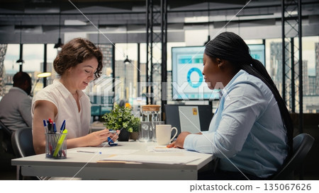 HR employee offers access key card to new hire after the interview, finalizing the onboarding process and registration after resume and CV approval. Welcoming to the team. Camera A. 135067626