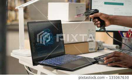 Guy using AI and scanner on awb shipping labels for tracking info with brain automation, package tracking software on a laptop nearby. Online shopping with neural networks support. Camera B. 135067630