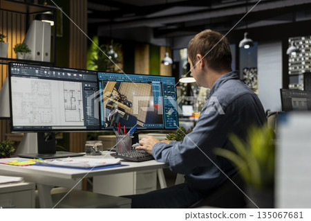 Male employee creates 3D render of an apartment interior using blueprints and architectural software. Using computer aided tools and models to allow customization of flooring and layout. 135067681