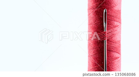 Red Sewing Thread Spool with Needle and Copy Space. High quality photo Red Sewing Thread Spool with Needle and Copy Space. High quality photo 135068086